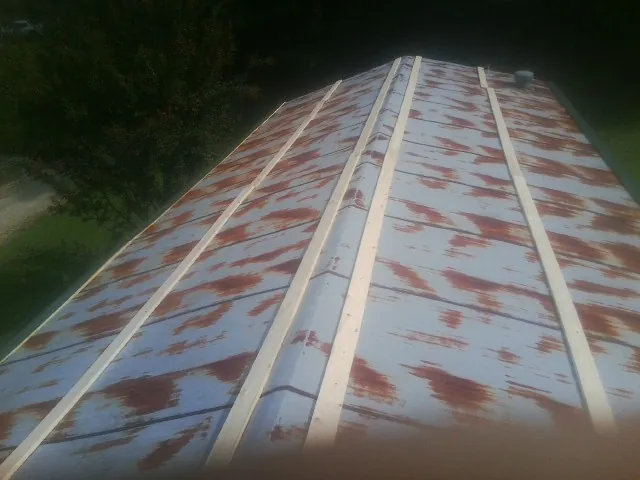 Rusted metal roof panels with new wood purlins before replacement — Storm Damage Roof Repair in Reesville by Roofing Brothers
