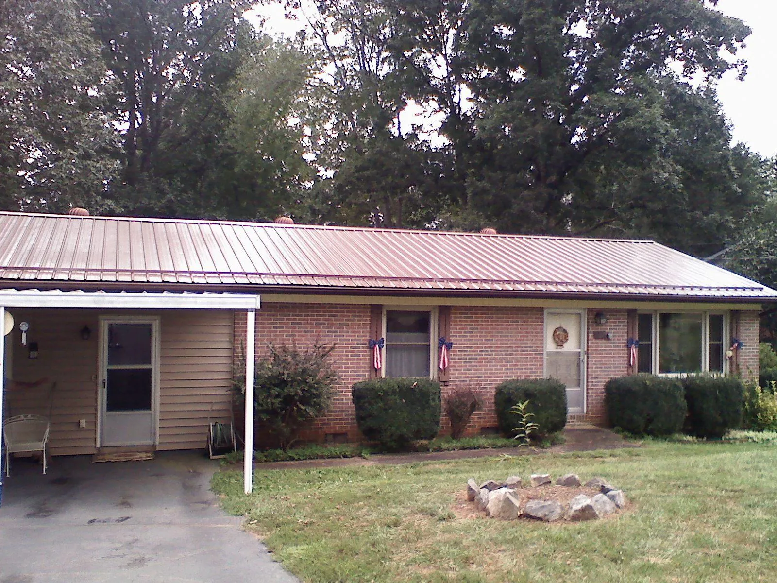 Bronze metal roof and carport on a brick ranch home — Roof Repair work by our crew in Reesville